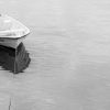 Two skiffs rest side by side in a busy fishing harbor.