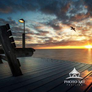 Bench and light facing the water as the sun sets over the Great South Bay in Sayville, NY. Suffolk