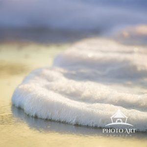 Close up of foam meeting the shoreline at Island Beach State Park, New Jersey in winter.