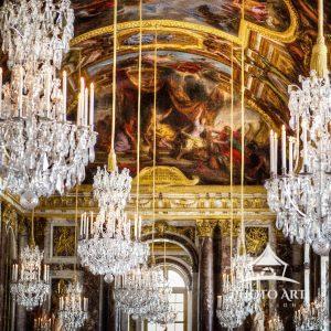 Chandeliers hanging from the painted ceiling in the Hall of Mirrors at Versailles, France.
