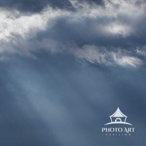 Dark blue sky with sun rays streaming through the clouds at Marsh Creek park, Pennsylvania.