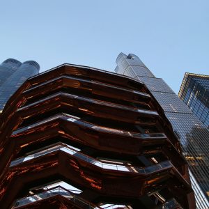 Looking up at The Vessel surrounded by other tall buildings in Hudson Yards.