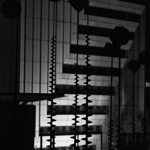 Abstract sculptures standing in a fountain in front of a modernist architecture hotel at night