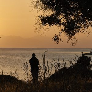 A lone soul ponders the eternal, lost in admiration of the wondrous creation that is Greece.