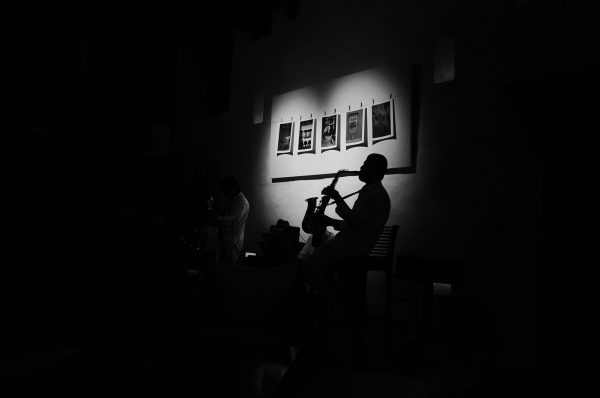 Saxophonist playing inside of heart light at jazz club. Cartagena, Colombia.
