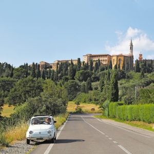 Vintage white Fiat 500 roadtripping throughout Tuscany, Italy.