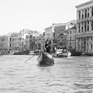 Gondolier with his gondola approaching from the Grand Canal of Venice, Italy. B&W.