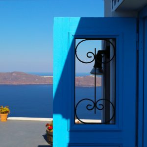 Greek blue door set in front of the mystical blue sea of Santorini, Greece.