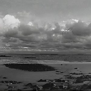 clouds roll in at the wells beach in maine as the tide is out..