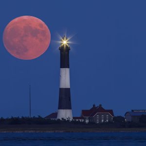 The Harvest moon dwarfs the Fire Island Lighthouse as it rises and the Lighthouse puts on it's own