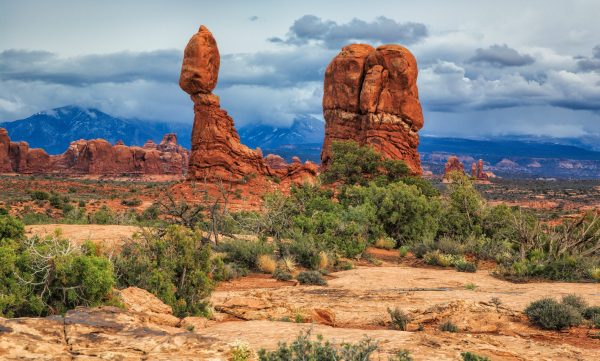 A balanced rock and other sandstone formations form a color counterpoint to the blue-tinged La Sal
