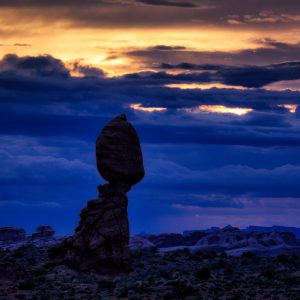 The last gasp of sunset light illuminates a portion of the sky at twilight around Balanced Rock in