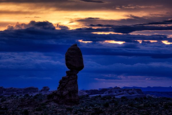 The last gasp of sunset light illuminates a portion of the sky at twilight around Balanced Rock in