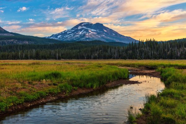 Sunset clouds hover over Mt. Bachelor from a meadow along the Cascade Lakes Scenic Byway outside