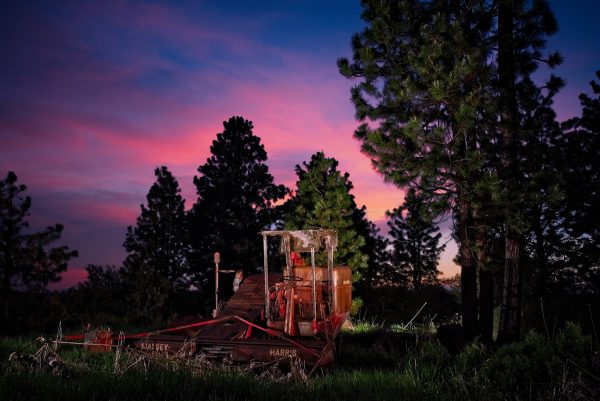 Old farming equipment with sunset