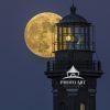 The Beaver moon rises behind the lamproom of the Fire Island Lighthouse as the light is doing it's