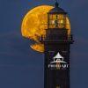 The 'Beaver' Full Moon breaks thru the clouds behind the lamproom of the Fire Island Lighthouse.