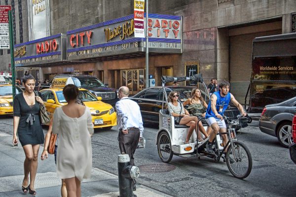 Pedicab, pedestrians, cars, and taxis all make an interesting composition outside of Radio City