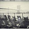 The image shows a monochromatic artwork that illustrates a scene with several Adirondack chairs