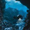 "Never Stop Exploring" is a stunning underwater photograph that captures a scuba diver navigating