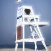 The photograph shows a lifeguard stand prominently positioned on the clean sand at Main Beach
