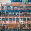 This stylized photograph shows a closeup of the Staten Island Ferry. The multiple decks are filled