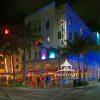 The photograph captures the vibrant night time street scene in South Beach. The focus is on a
