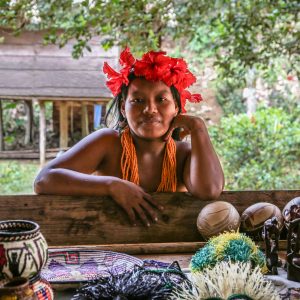 Woman from the indigenous Embera village posing with traditional striking red floral crown. Panama,