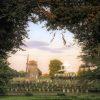 This scenic photograph captures a picturesque windmill on a serene, lush landscape. The windmill