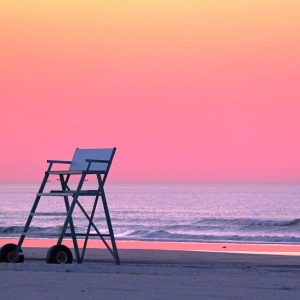 Dawn light reflecting on the Atlantic Ocean with a lifeguard stand turned around in an "off-duty"