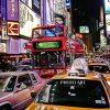 This photo shows a bustling city scene at night, with bright, colorful lights illuminating the