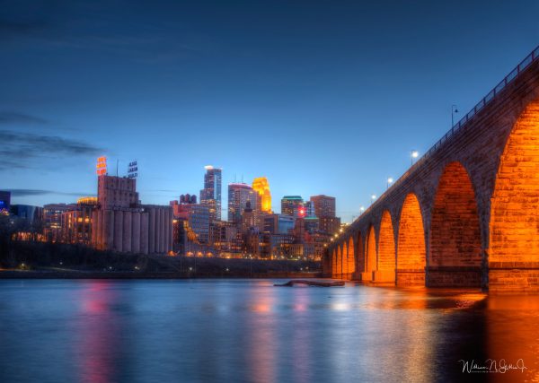 Sunset image of downtown Minneapolis and the Stonearch bridge crossing the Mississippi river. HDR