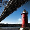  This photograph captures the vivid red lighthouse situated beneath the George Washington Bridge.