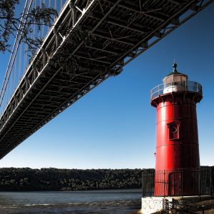  This photograph captures the vivid red lighthouse situated beneath the George Washington Bridge.