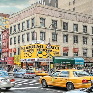 This colorful photo depicts a bustling city street scene with a prominent corner building, home of