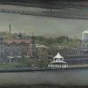 This is an old-style photograph of Ellis Island. It features the historic brick buildings situated