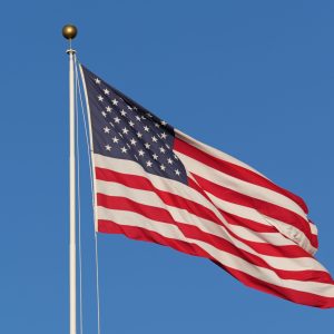 Formation of faces in the American flag blowing in the wind on a cloudless day.