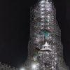 The spire scaffolding tops out in the darkness, but the work goes on 24/7.