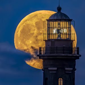 The 'Beaver' Full Moon breaks thru the clouds behind the lamproom of the Fire Island Lighthouse.