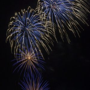Blue bursts light up the sky with trails of gold