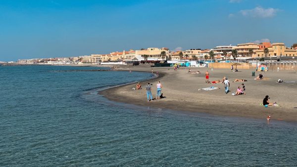 The photograph captures the sweeping expanse of Lido di Ostia, Rome’s beloved seaside retreat, where