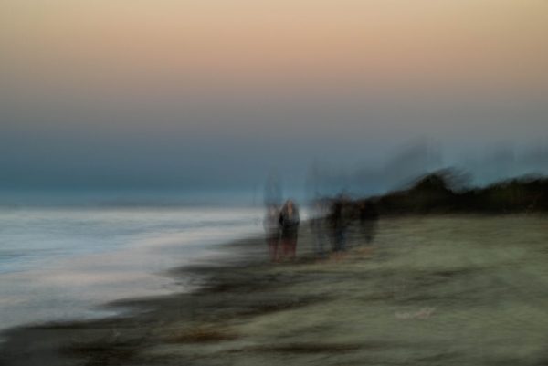 Day's end. Last rays of sunlight as the sun sets below the horizon. A quiet walk along the beach