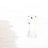 Three friends strolling along the beach at low tide, as sunset approaches. Walking at the water's