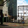 Two men crossing above the railroad tracks in NY’s Long Island City was the inspiration for