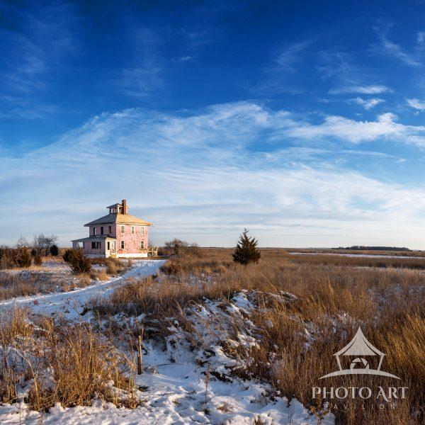 An isolated abandoned house on the Newbury marsh in the cold of winter.