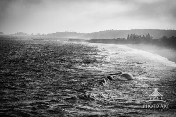 Fog, rain, and the low light of sunset enhance the shadows waves cast on the ocean's surface. The