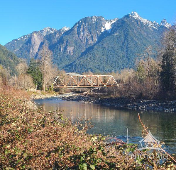 Summer view of the Skykomish River with train bridge and Mountains