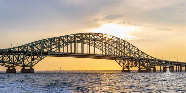 Yacht out for a sunset sail clears the Robert Moses Bridge.