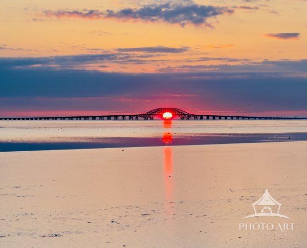 A brilliant Long Island sunrise aligns perfectly beneath the arch of the Robert Moses Causeway