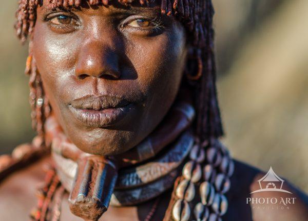 The large metal necklace worn by this Hamar woman denotes that she is the first wife of three wives.